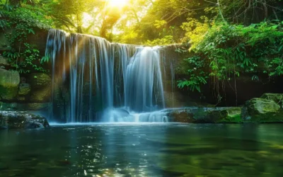 A Vibrant, Cascading Waterfall Surrounded By Lush, Emerald Foliage Reflects The Sun's Golden Rays, Creating A Serene Oasis That Embodies Tranquility And Natural Beauty.